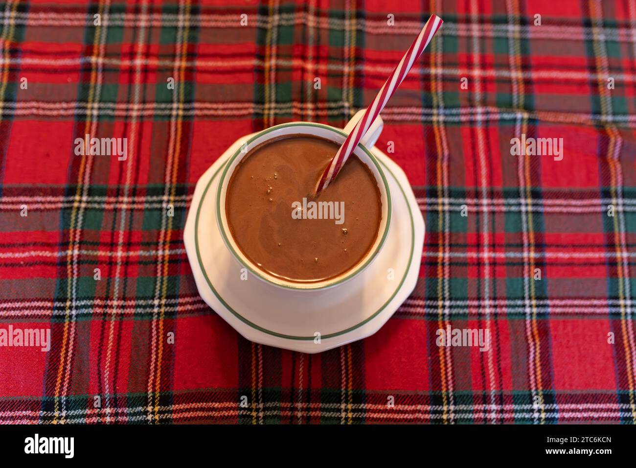 Tasse heiße Schokolade auf einer weihnachtlich farbigen Tischdecke Stockfoto