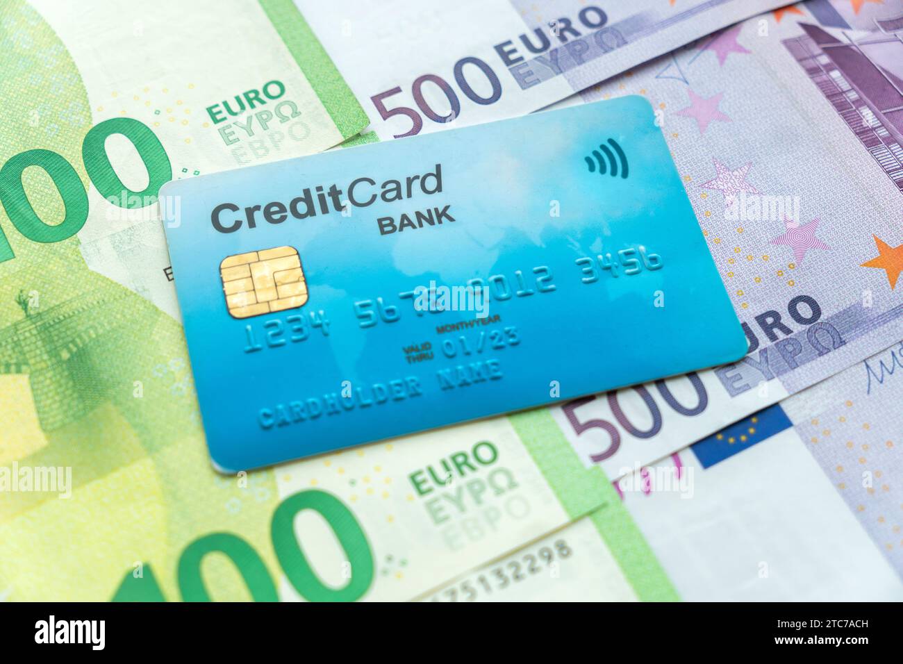 Geld und Kreditkarten. Die blaue Kreditkarte ist auf Bargeld in Euro. Konzept für Konto mit mehreren Währungen in verschiedenen Währungen. Stockfoto