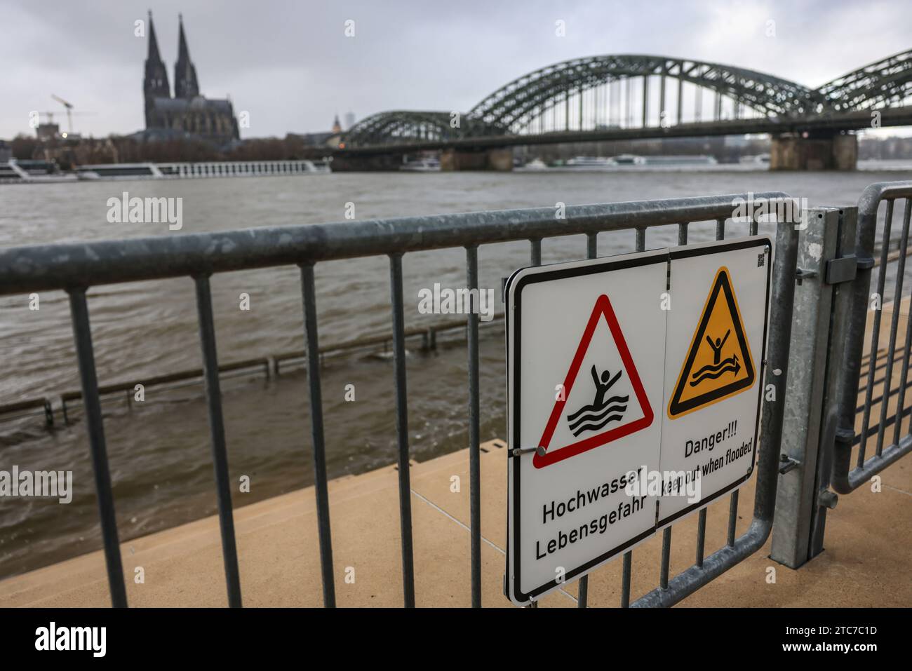Köln, Deutschland. Dezember 2023. Schilder mit der Aufschrift "Flut - Lebensgefahr" hängen an der abgesperrten Treppe am Rheinufer. Eine Kombination von Regen und Tauwetter kann für Flüsse in Teilen Süd- und Westdeutschlands zu einem Problem werden. So steigen beispielsweise die Wasserstände am Rhein aufgrund der aktuellen Niederschläge im südlichen Einzugsgebiet. Quelle: Oliver Berg/dpa/Alamy Live News Stockfoto