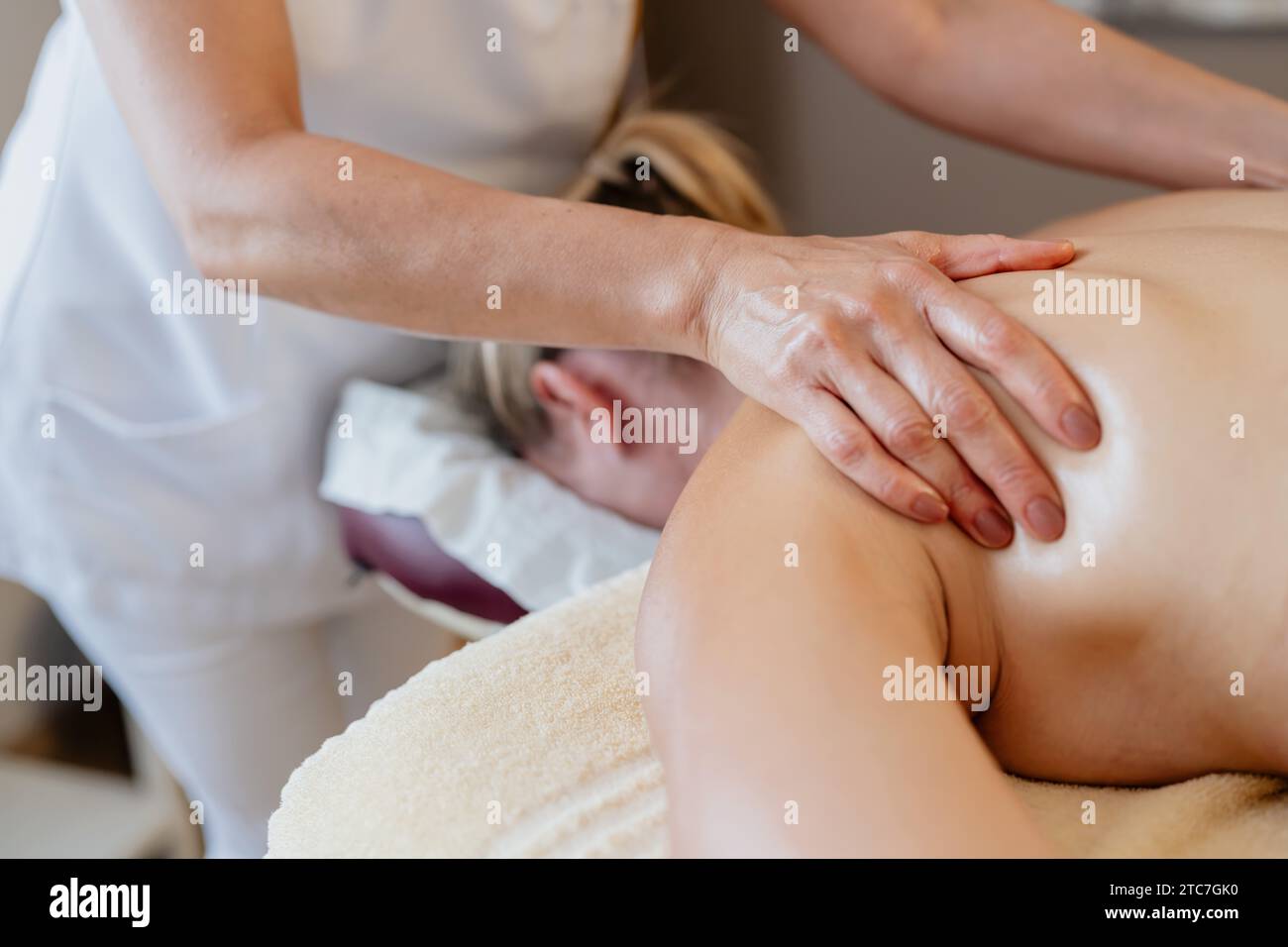 Nahaufnahme eines Massage-Therapeuten, der in einem Spa-Schönheitssalon auf der Schulter eines Kunden arbeitet Stockfoto