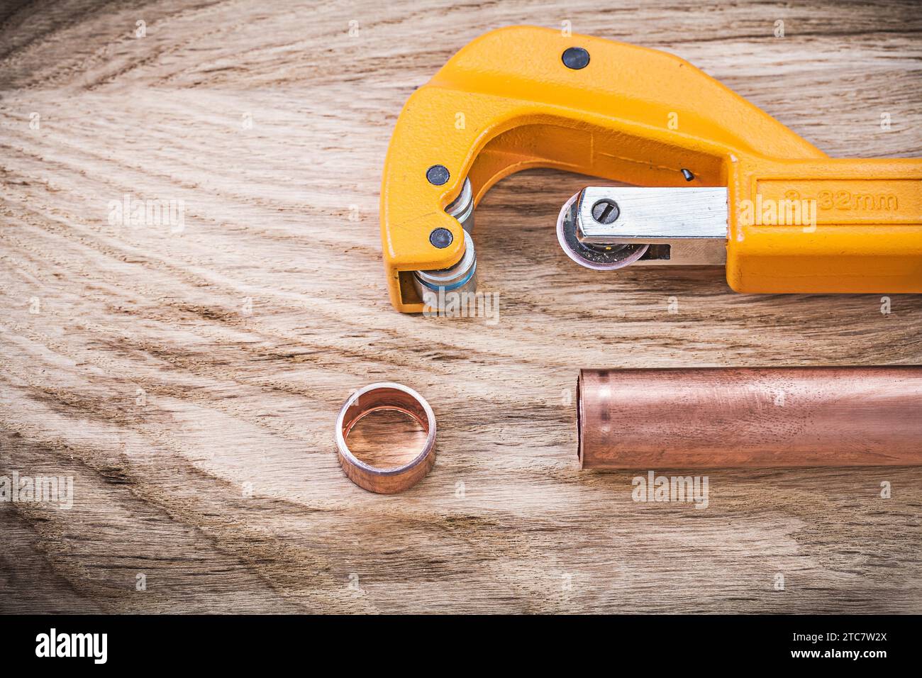 Kupferwasserrohrschere auf Holzbrett Sanitär-Messingware-Konzept Stockfoto