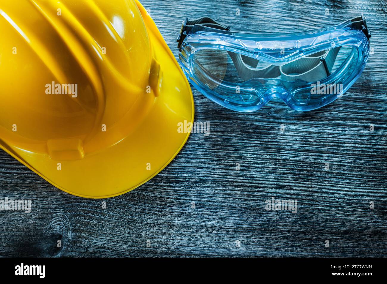 Schutzbrille Bauhelm auf Vintage-Holzbrett Stockfoto