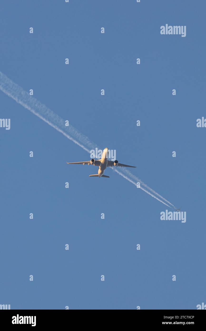 Singapore Airlines A350-941, reg 9V-SJB in geringer Höhe, nähert sich dem Flughafen Manchester zur goldenen Stunde mit einem Contrail eines anderen Flugzeugs in der Ferne Stockfoto