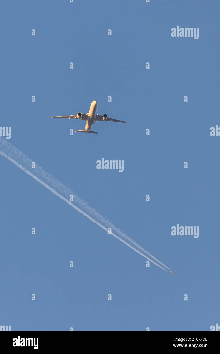 Singapore Airlines A350-941, reg 9V-SJB in geringer Höhe, nähert sich dem Flughafen Manchester zur goldenen Stunde mit einem Contrail eines anderen Flugzeugs in der Ferne Stockfoto