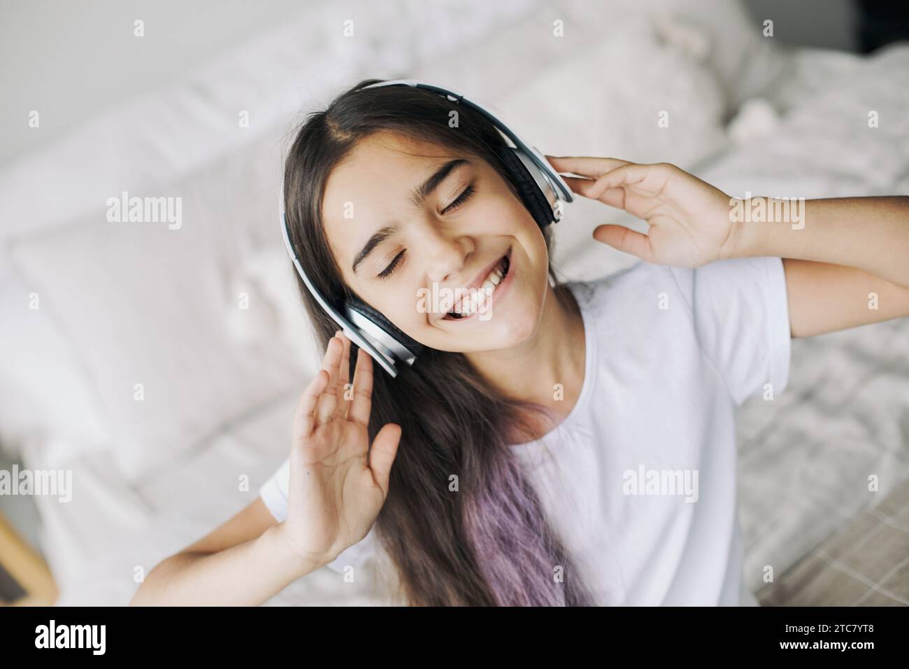Hübsches Mädchen, das vor Teenagern lebt, hört Musik über kabellose Kopfhörer, Nahaufnahme des Gesichts. Moderne Technik, Spaß, Freizeit Stockfoto