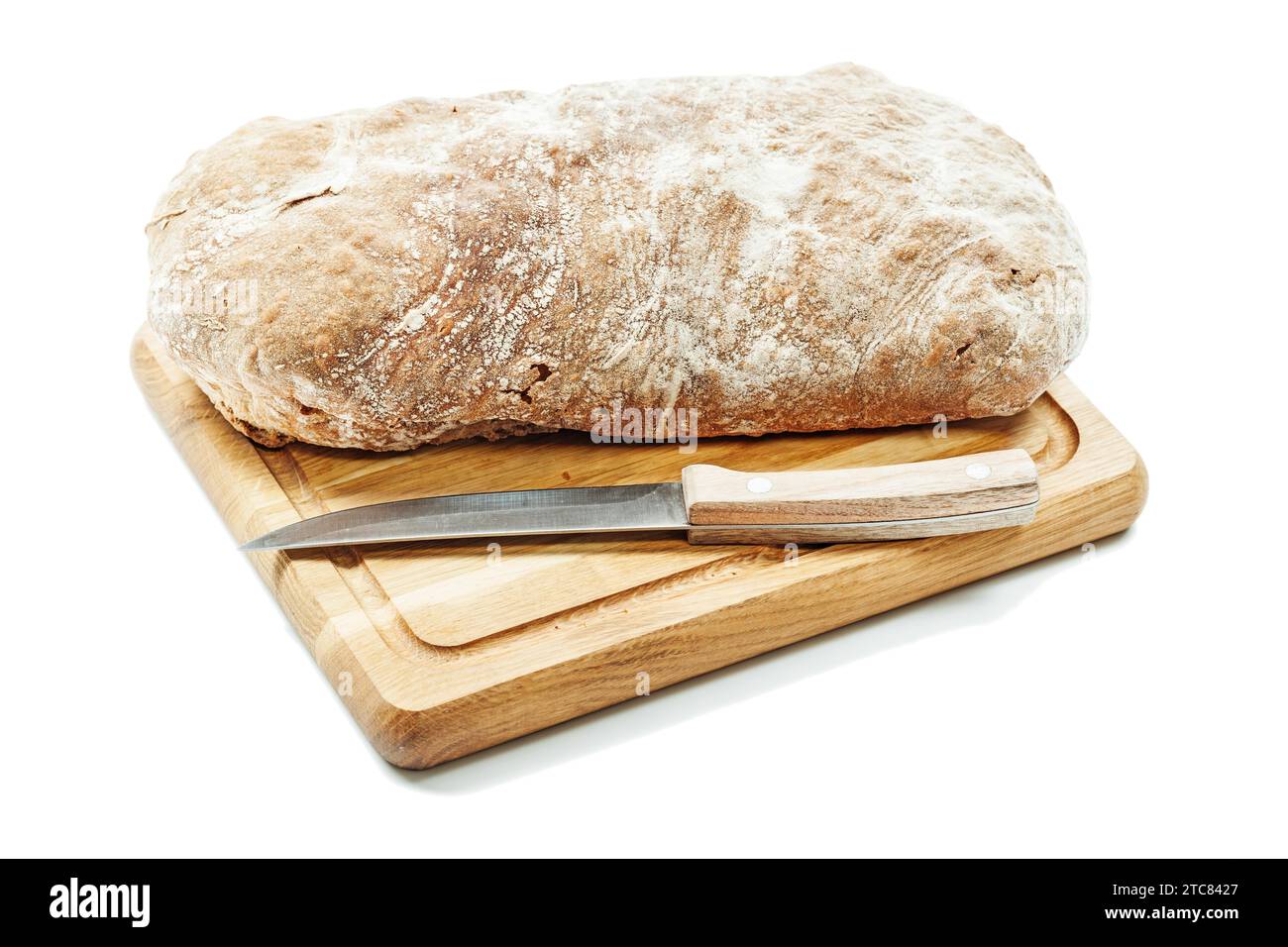 Brotbrot auf Schnitzerbrett mit Küchenmesser isoliert Stockfoto