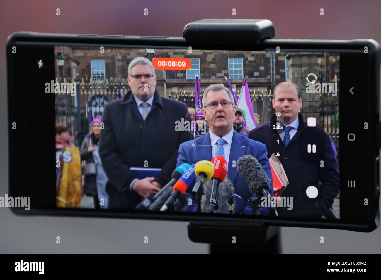 Ein Telefon meldet (von links nach rechts) den stellvertretenden Vorsitzenden der DUP Gavin Robinson, den Führer der DUP Sir Jeffrey Donaldson und Gordon Lyons, der nach Gesprächen zwischen dem nordirischen Sekretär Chris Heaton-Harris und den wichtigsten politischen Parteien mit Medien vor Hillsborough Castle sprach. Bilddatum: Montag, 11. Dezember 2023. Stockfoto