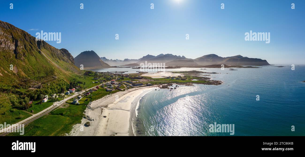 Panoramablick auf die Bucht von Jusnesvika mit dem Strand Rambergstranda auf Flakstadoya Island, Lofoten, Norwegen, mit einem bezaubernden Dorf, einem geschwungenen Sch Stockfoto
