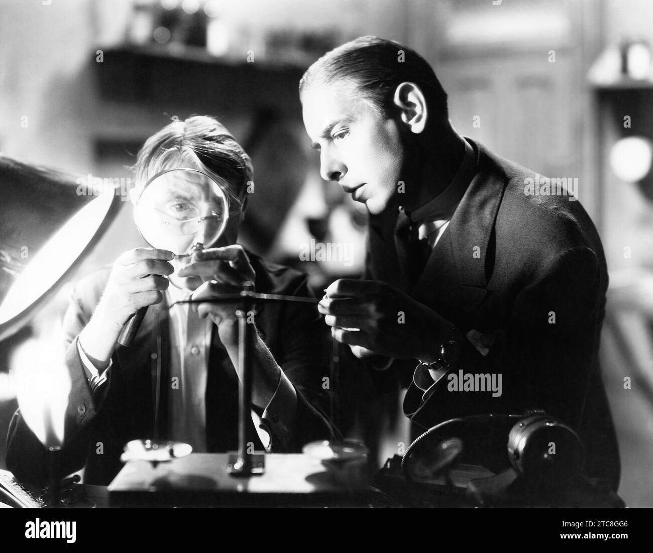 Zwei Männer inspizieren Schmuck unter einer Lupe (OV2023 11) Stockfoto