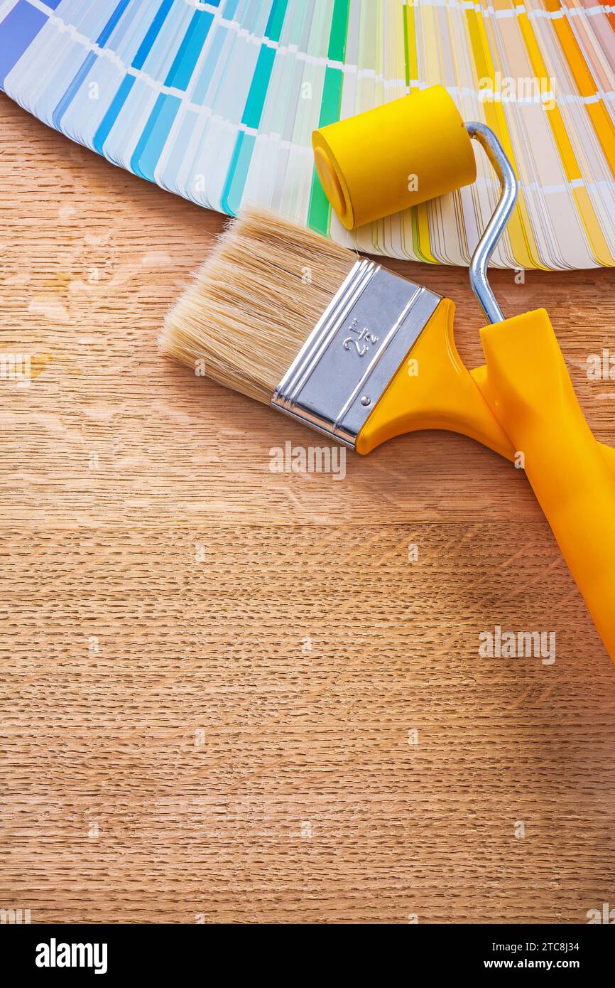 Malerwalzenpinsel und pantone-Farbpalette zum Baukonzept Holzbretter Stockfoto