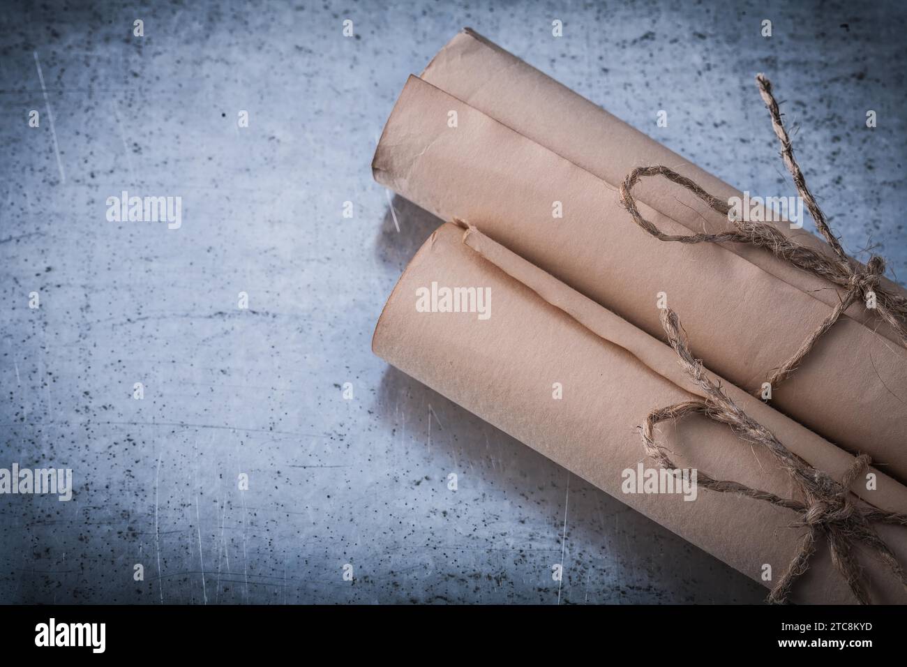 Langjähriges Papier läuft auf zerkratzter Metalloberfläche Stockfoto