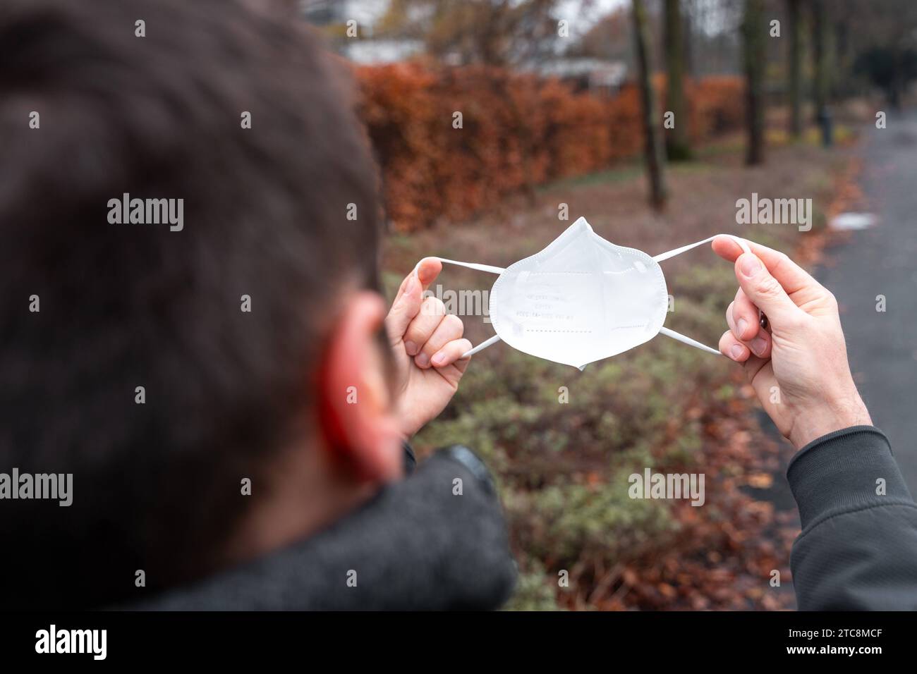 Rotterdam, Niederlande - 5. Dezember 2023: Ein Mann zieht eine FFP2-Maske zum Schutz vor dem COVID-19-Virus an *** ein Mann zieht eine FFP2-Maske zum Schutz vor dem COVID-19-Virus an Credit: Imago/Alamy Live News Stockfoto