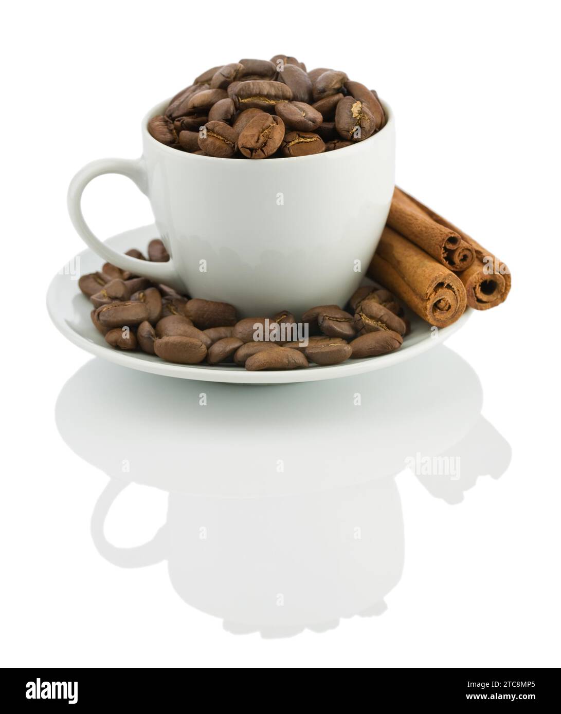 Tasse mit Kaffeebohnen und Zimtstangen isoliert Stockfoto