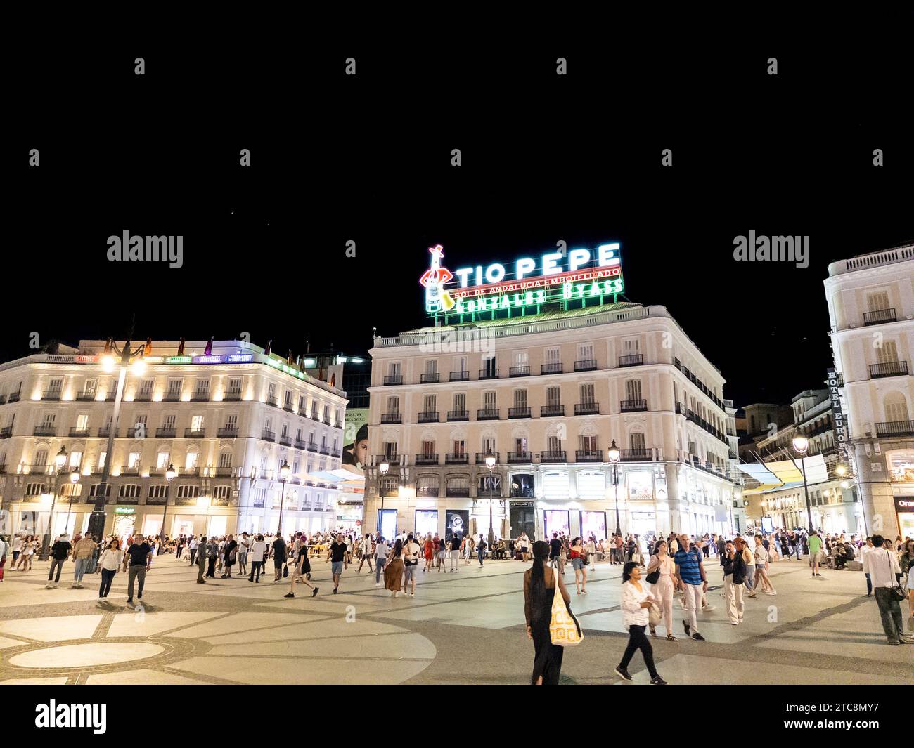Madrid, Spanien - 29. August 2023: Das ikonische Tio Pepe Neonschild auf einem Gebäude, das die geschäftige Puerta del Sol bei Nacht darstellt Stockfoto