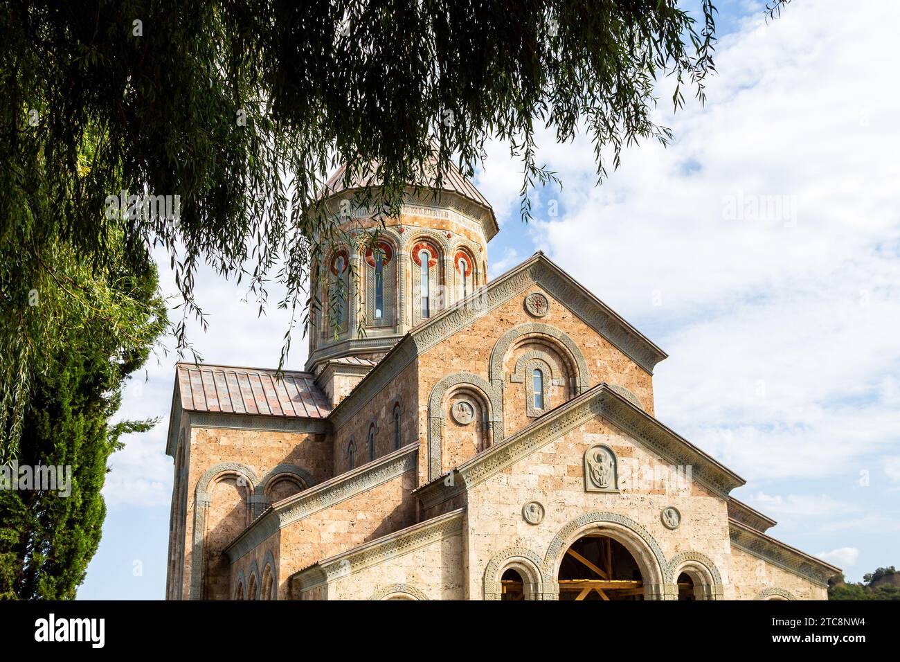Bodbe, Georgien - 24. September 2023: Grüner Baum und neue St. Nino Kirche im Bodbe Kloster in der Region Kakheti in Georgien am sonnigen Herbsttag Stockfoto