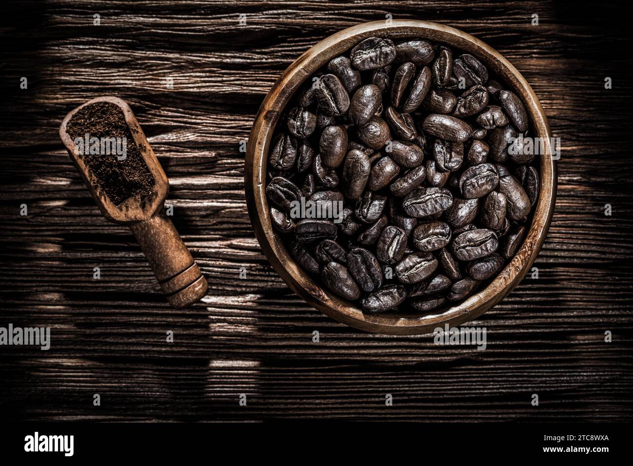 Gemahlene Kaffeekörner Schüssel Schaufel auf Holzbrett Stockfoto