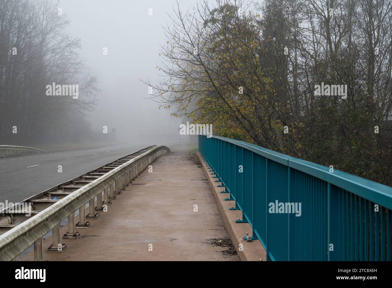 Leere Lebensmittelbrücke, die an einem nebeligen Morgen die Autobahn überquert, Dilbeek, Brabant, Belgien Stockfoto