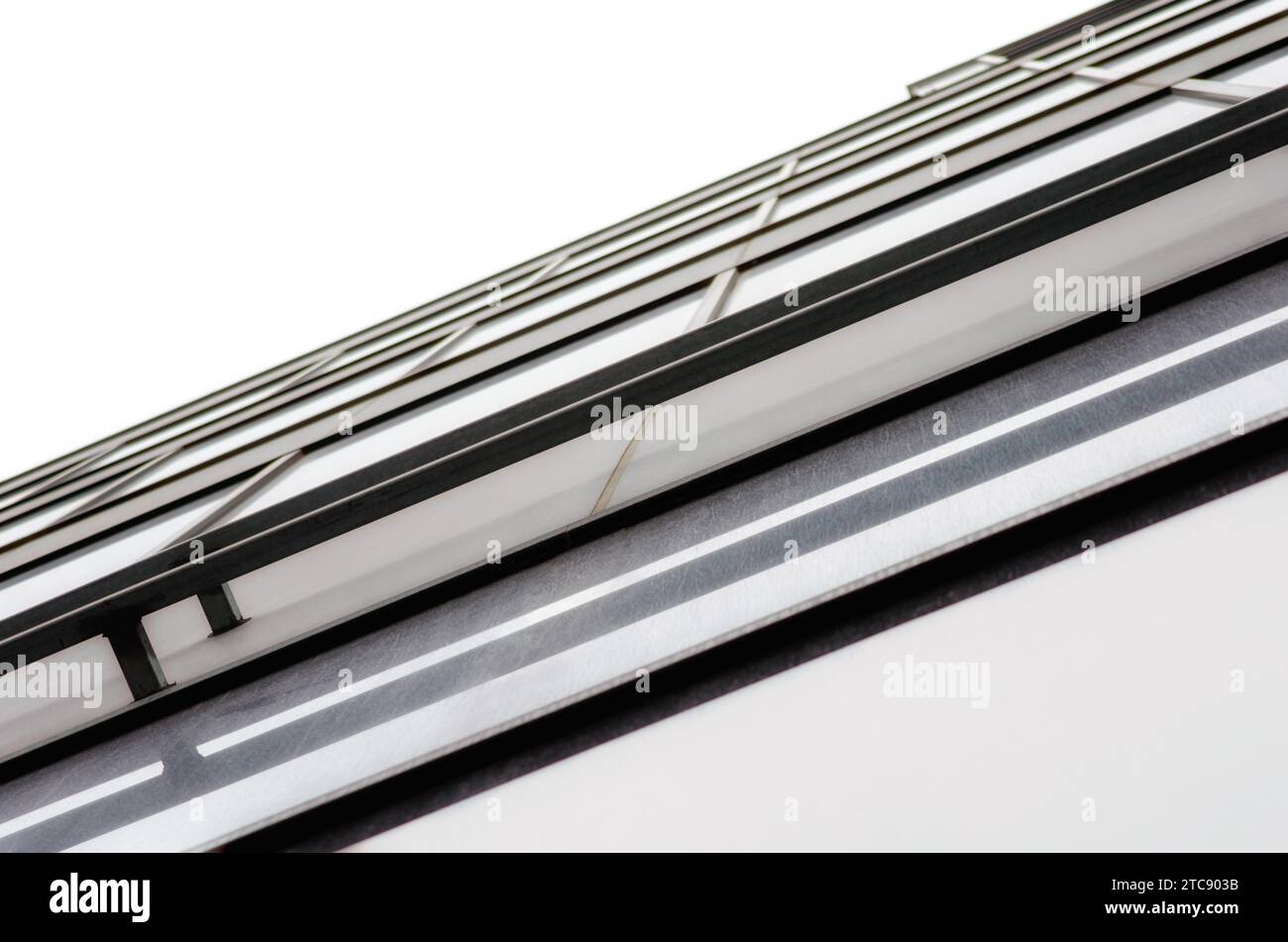 Fragment der Wand und Fenster eines modernen hohen Bürogebäudes ohne abstrakten architektonischen monochromatischen Hintergrund Stockfoto