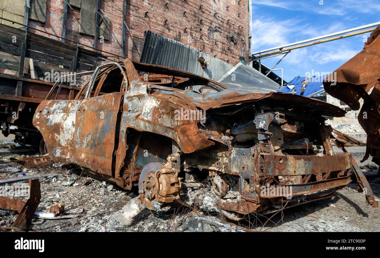 Verbrannter militärischer Panzerwagen auf der Straße des zerstörten Stadtkrieges Ukraine Russland Stockfoto