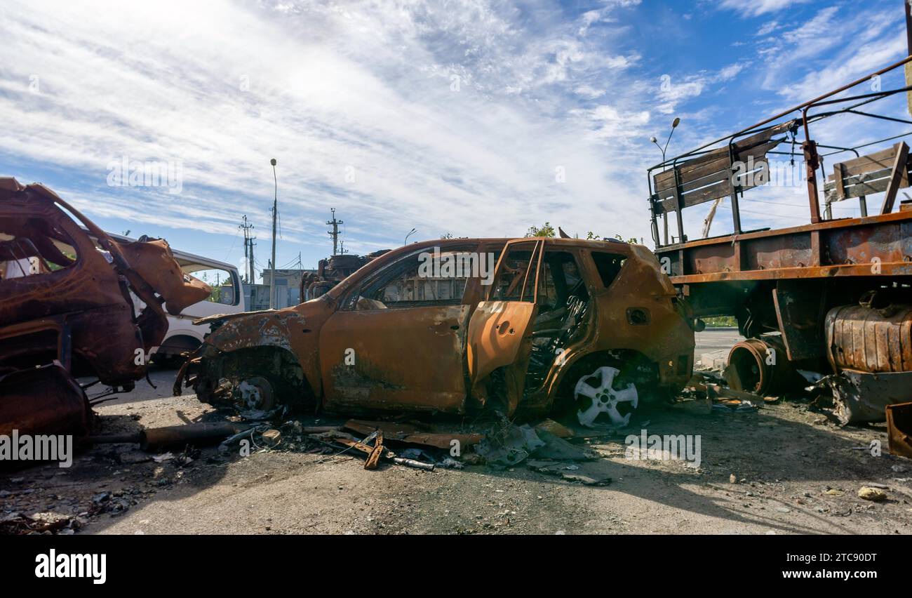 Verbrannter militärischer Panzerwagen auf der Straße des zerstörten Stadtkrieges Ukraine Russland Stockfoto