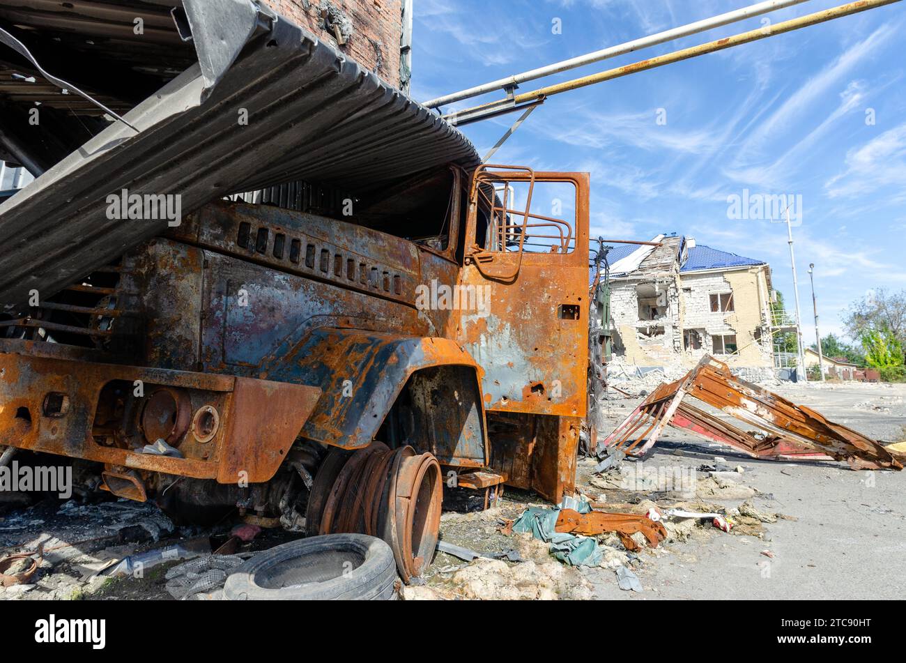Verbrannter militärischer Panzerwagen auf der Straße des zerstörten Stadtkrieges Ukraine Russland Stockfoto