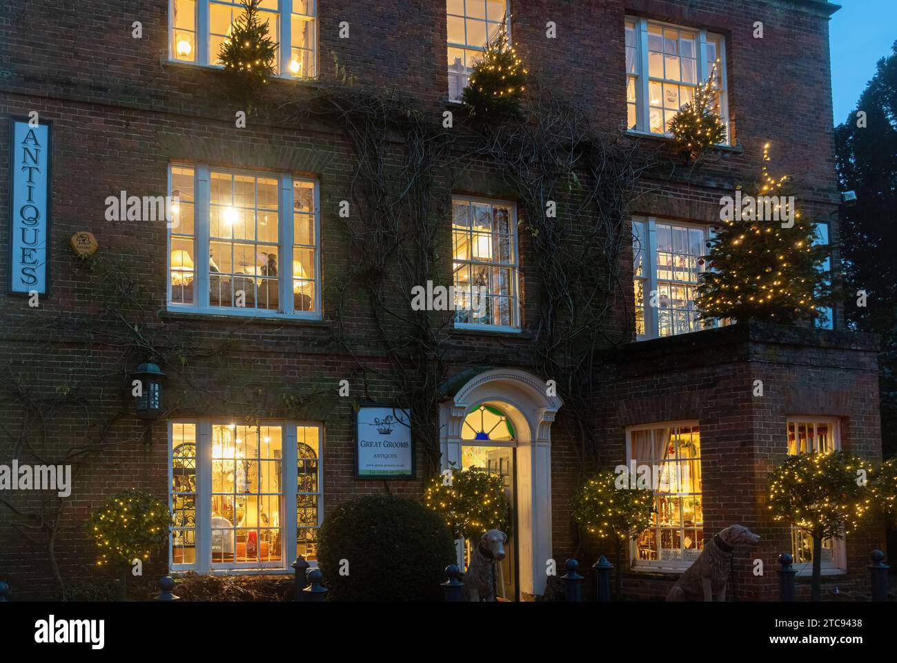 Great Grooms Antiques Showrooms in einem großen Haus, ein Antiquitätengeschäft in Hungerford, West Berkshire, England, Großbritannien, Außenansicht bei Nacht zu Weihnachten Stockfoto