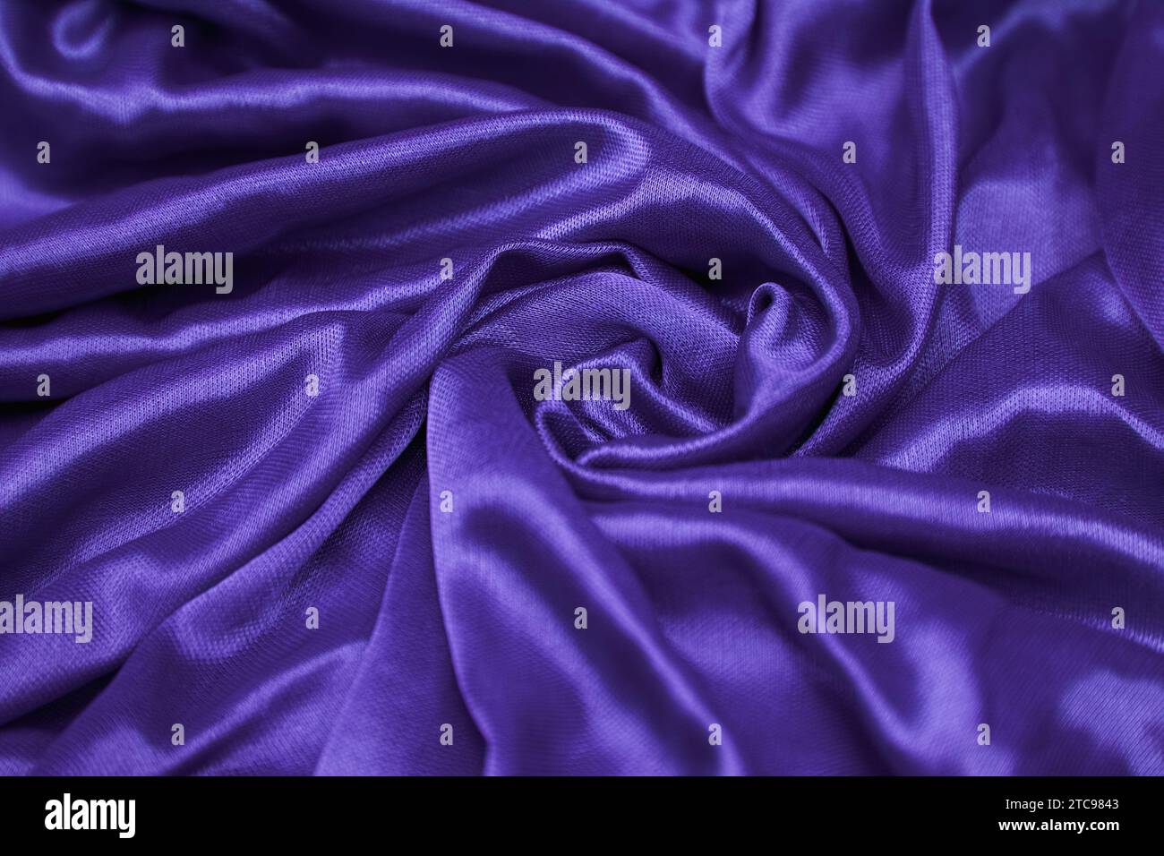 Eine Makroaufnahme aus luxuriösem, glattem violettem Seidengewebe, perfekt für eine Vielzahl kreativer Projekte und Designs Stockfoto