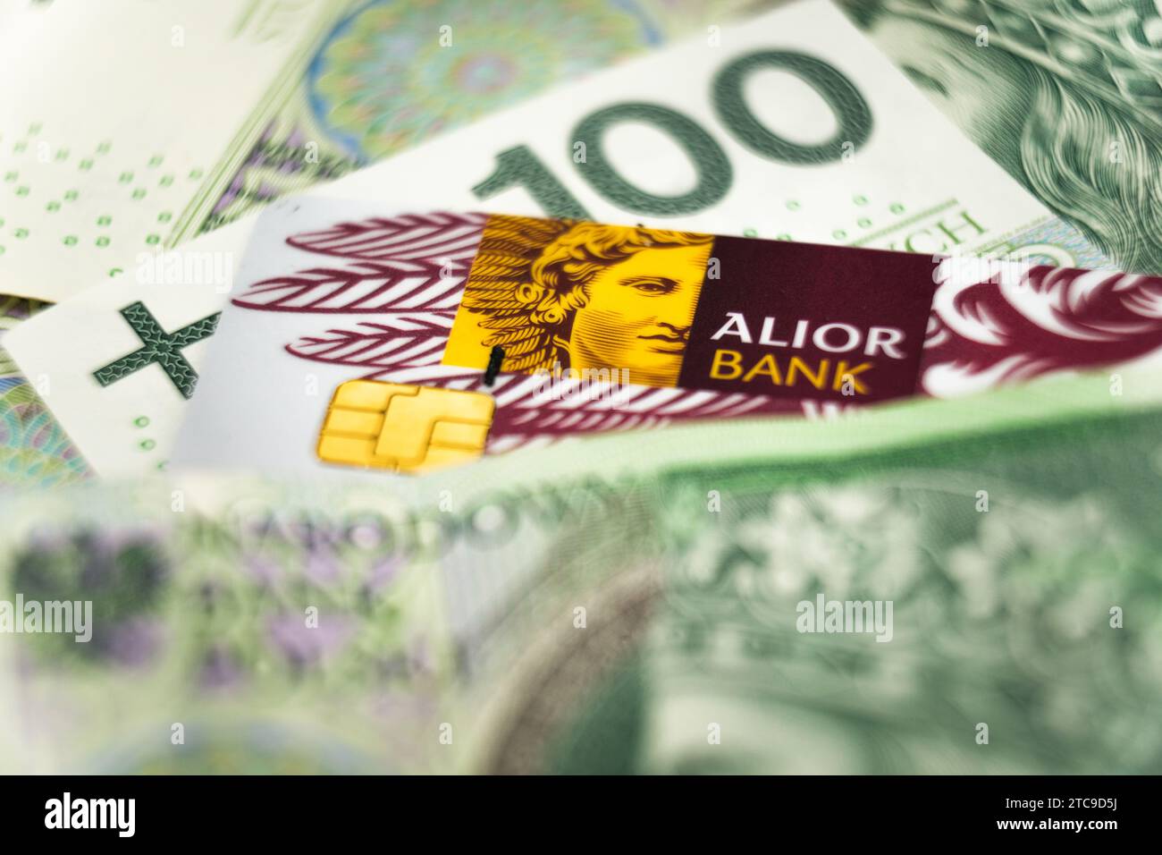 Wałbrzych, polen - 11.12.2023: Alior-Banklogo auf einer Kreditkarte unter polnischen Zloty-Banknoten Stockfoto