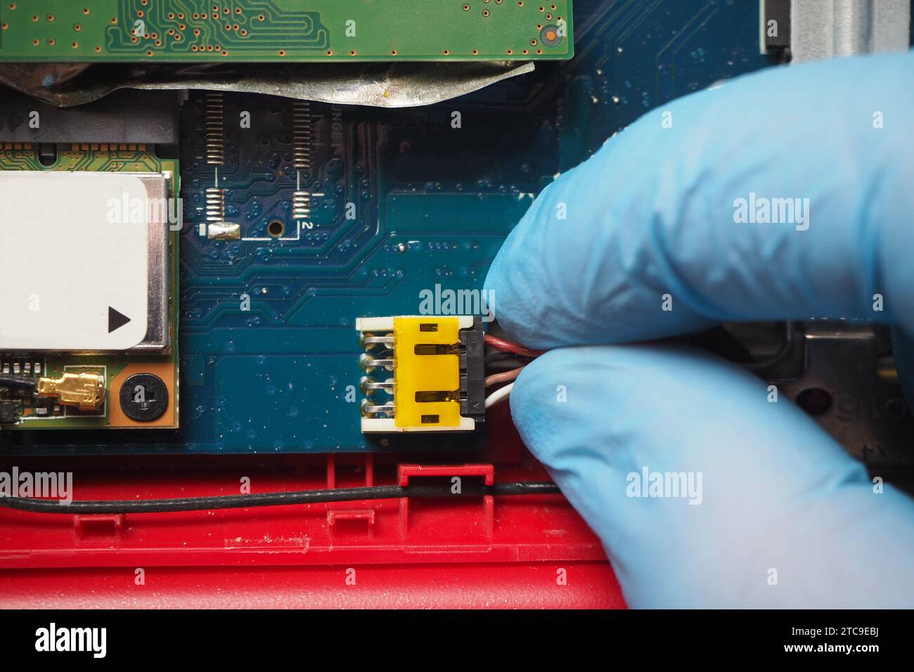 Techniker, der das 8-polige Daten- und Stromkabel an den Anschluss auf der elektronischen Leiterplatte anschließt. Stecken Sie das Kabel von Hand in die Buchse auf der Hauptplatine. Stockfoto