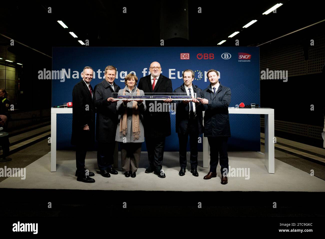 Berlin, Deutschland. Dezember 2023. Volker Wissing l-r, FDP), Bundesminister für digitale Angelegenheiten und Verkehr, Richard Lutz, CEO der Deutschen Bahn AG, Sophie Dutordoir, CEO der belgischen Staatsbahnen NMBS/SNCB, Andreas Matthä, CEO der österreichischen ÖBB-Holding, Christophe Fanichet, CEO der französischen SNCF Voyageurs, Clément Beaune, französischer Verkehrsminister, halten Sie beim Start des ersten Nightjet von Berlin nach Brüssel und Paris am Berliner Hauptbahnhof ein Modell mit einem Zug. Quelle: Carsten Koall/dpa/Alamy Live News Stockfoto