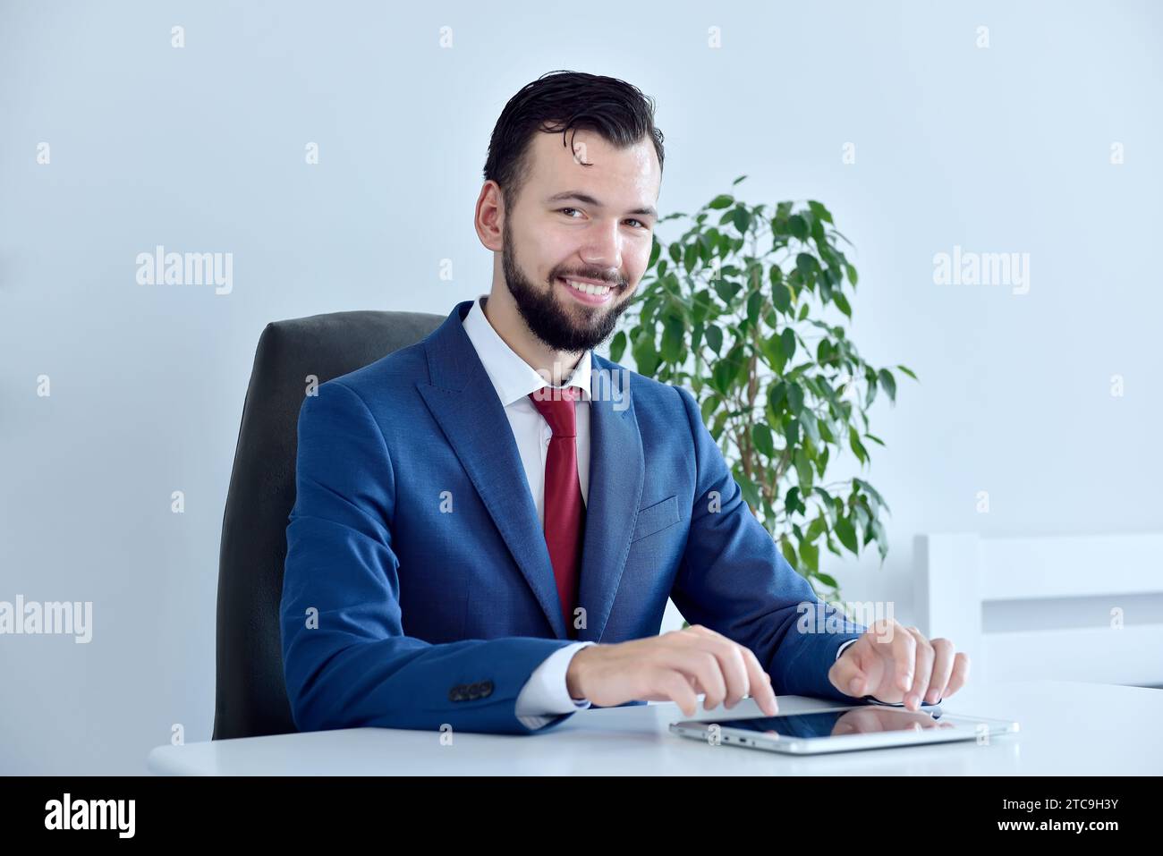 Büroleiter sitzt im Büro und verwendet ein digitales Tablet. Konzept der Geschäfts- und Finanzanalyse. Stockfoto