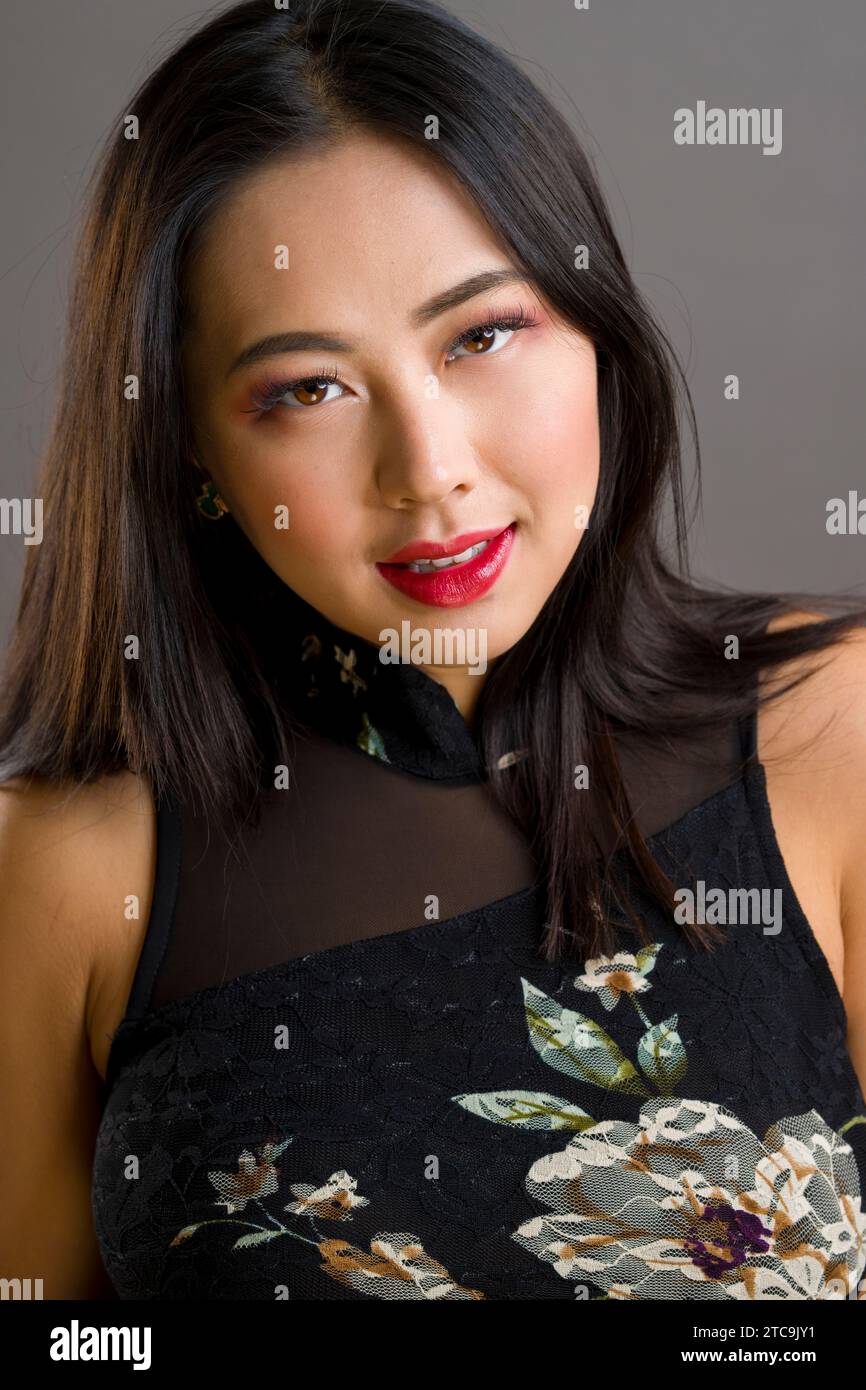 Schöne junge asiatische Frau Curvy Fit sportliche Cheongsam mit Blumenmuster Stockfoto