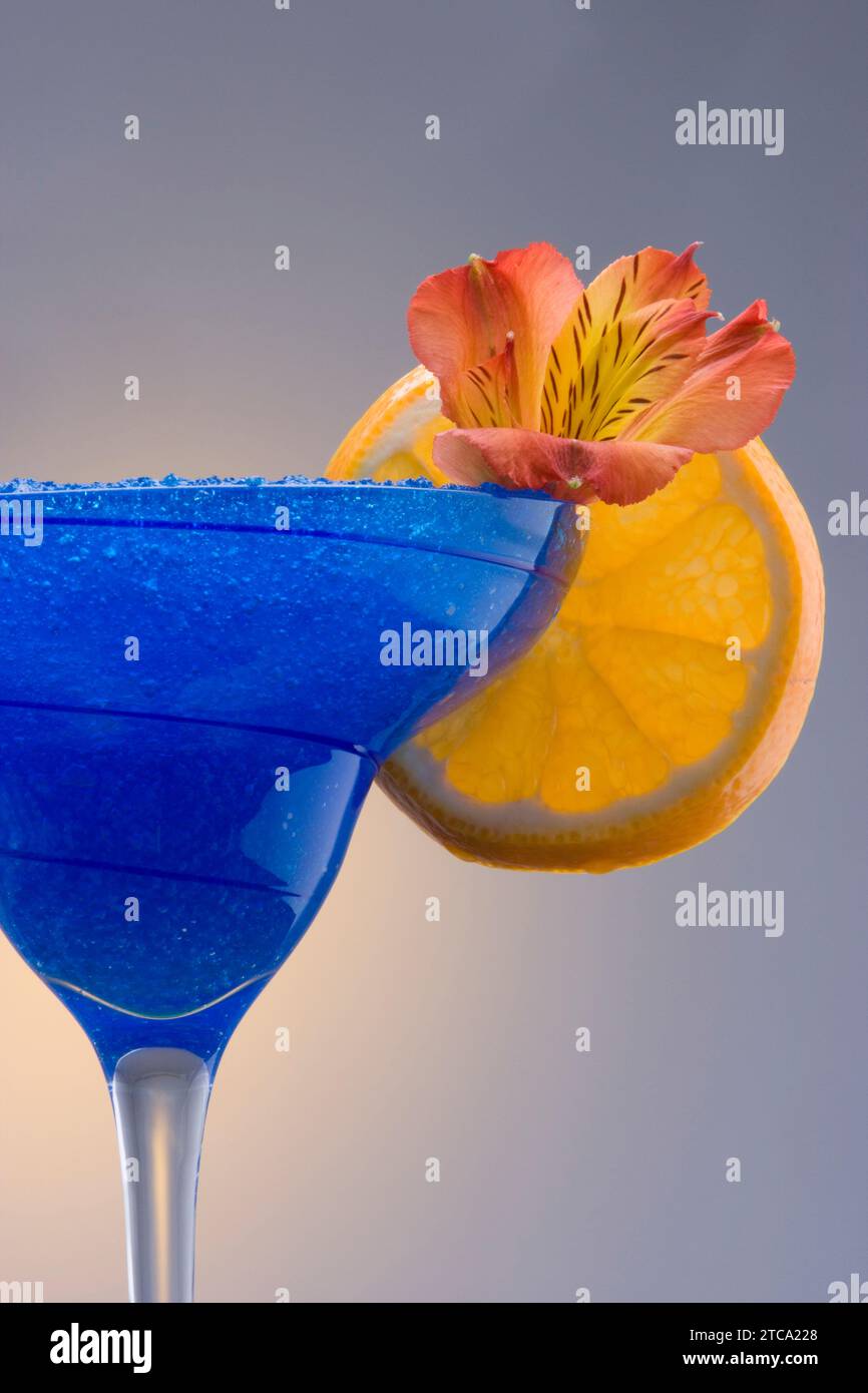 Blue Hawaiian Mischgetränk mit Orchideen und orange garnieren auf einfarbigen Hintergrund Stockfoto