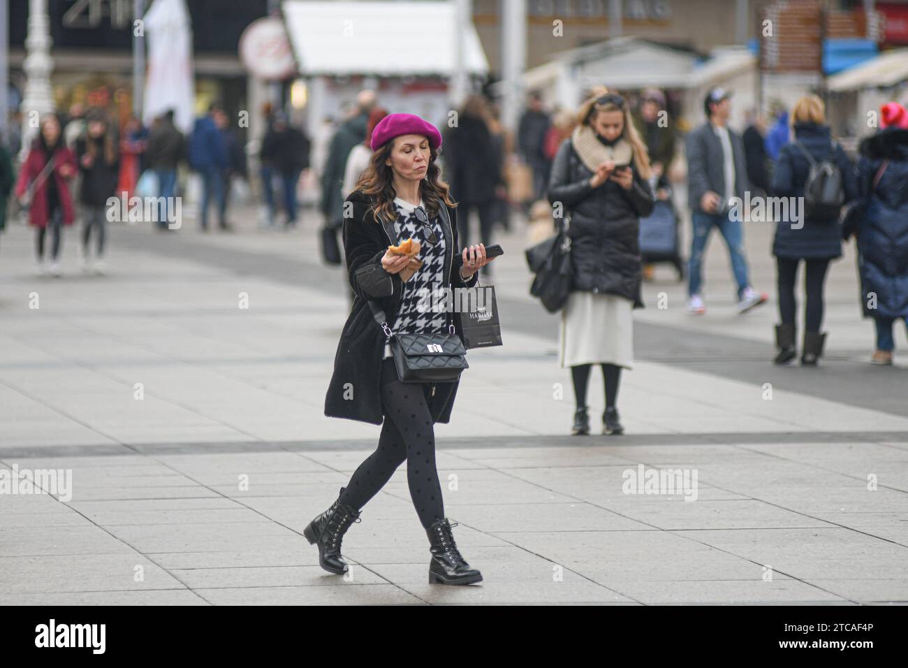 Kroatische Frau isst einen Snack auf dem Ban Jelacic-Platz, Zagreb, Kroatien Stockfoto