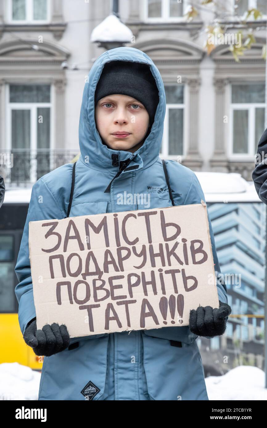 Im Zentrum von Lemberg steht ein Junge mit einem Poster „statt Geschenke, gib meinen Vater zurück“. Verwandte und Freunde von Gefangenen des Asov-Regiments nehmen an der alles ukrainischen Aktion „sei nicht still! Töte dich! Die Ukraine wartet auf die Rückkehr ihrer Helden in die Heimat", in Lemberg, Ukraine? Sie versammelten sich, um an die gefangenen Verteidiger von Mariupol zu erinnern, die seit 19 Monaten in russischer Gefangenschaft sind und dort gefoltert werden. Gleichzeitig fand eine solche Aktion in vielen Städten der Ukraine statt. Stockfoto