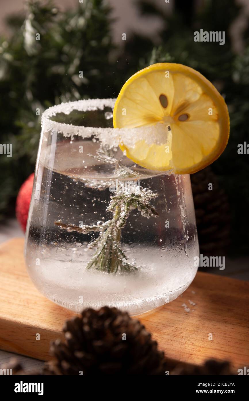 Schneekugel-Cocktail. Weihnachtsgetränk, kreatives Festgetränk im Glas, dekoriert mit Rosmarinzweig wie eine weihnachtskiefer, Zitrusscheibe Stockfoto