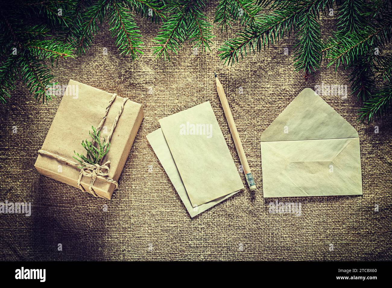 Geschenkbox Tannenzweig Papier Briefumschlag Bleistift auf Beuteloberfläche Stockfoto