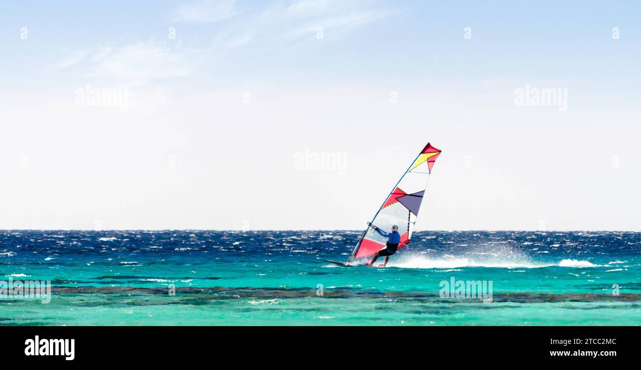 Surfer reiten im Roten Meer vor dem Hintergrund eines klaren Himmels in Sharm El Sheikh Stockfoto
