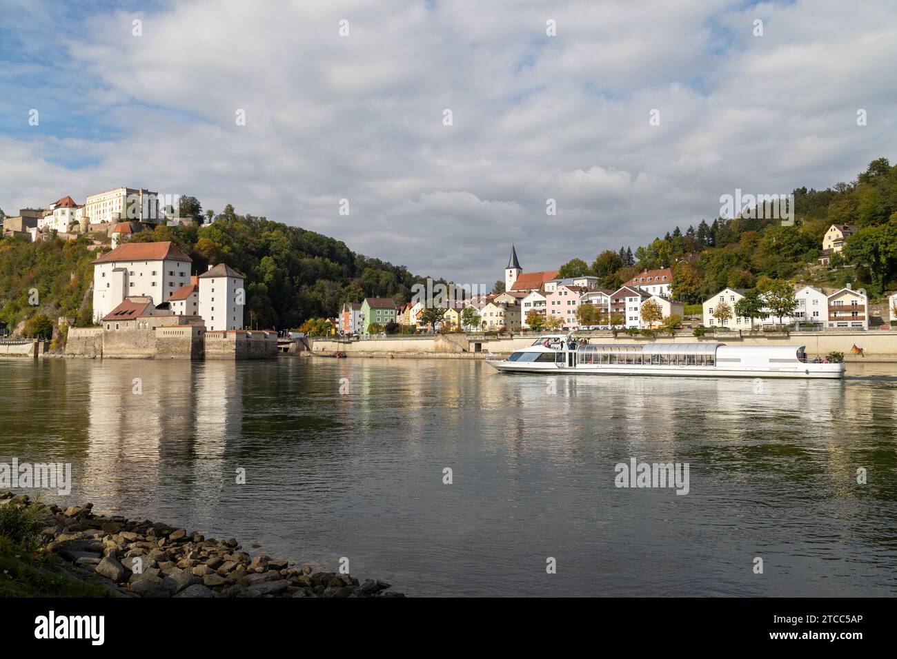Blick auf Burg Veste Oberhaus, Donau Ufer und Fluss Ilz in Passau, Bayern, Deutschland im Herbst mit Donau und Fahrgastschiff Stockfoto