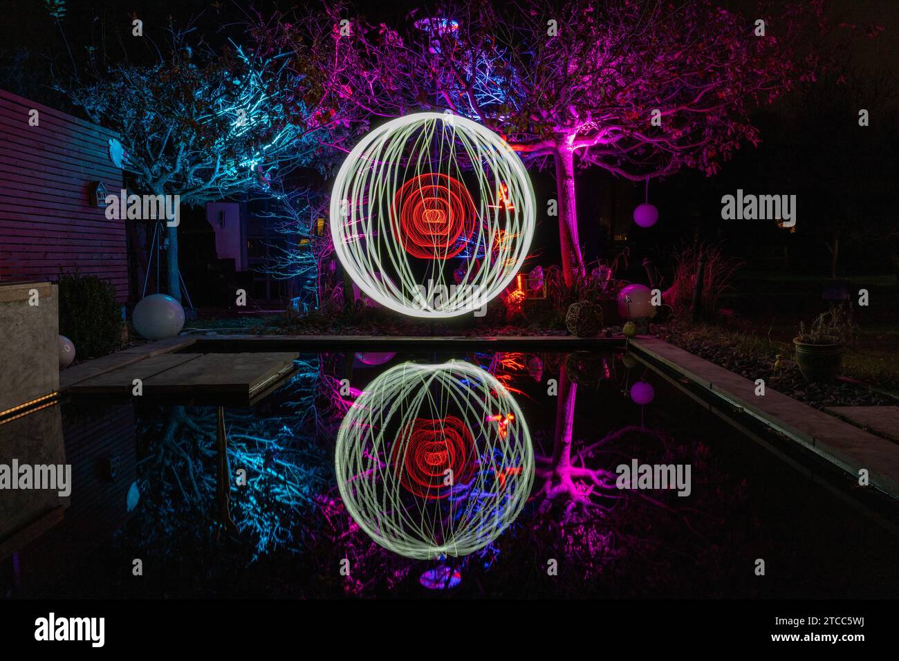 Lichtmalerei mit bunt beleuchteten Bäumen und Reflexen im Wasser Stockfoto