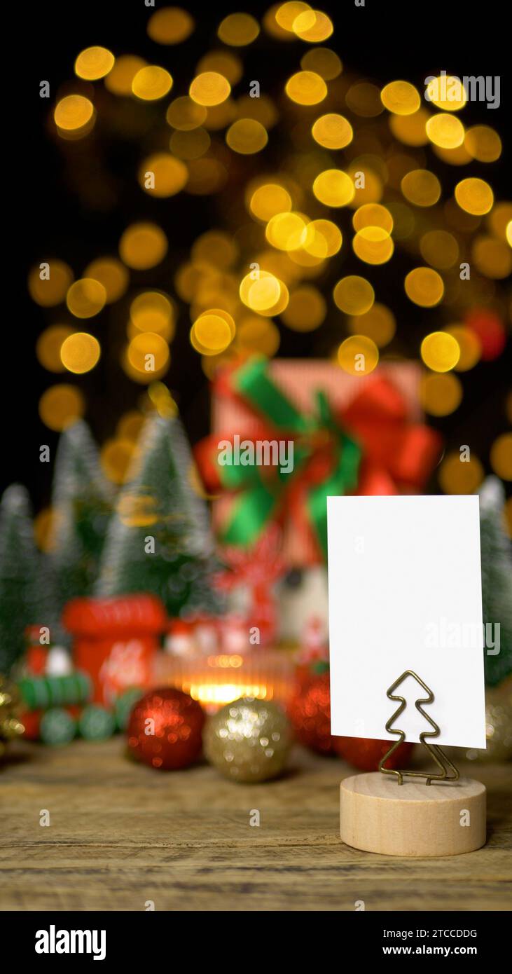 Weihnachtsgeschenkbox Geschenk mit vertikalem leerem weißem Papier für Grußkarte oder Einladungskarte mit Kopierraum für die Weihnachtsfeier Stockfoto
