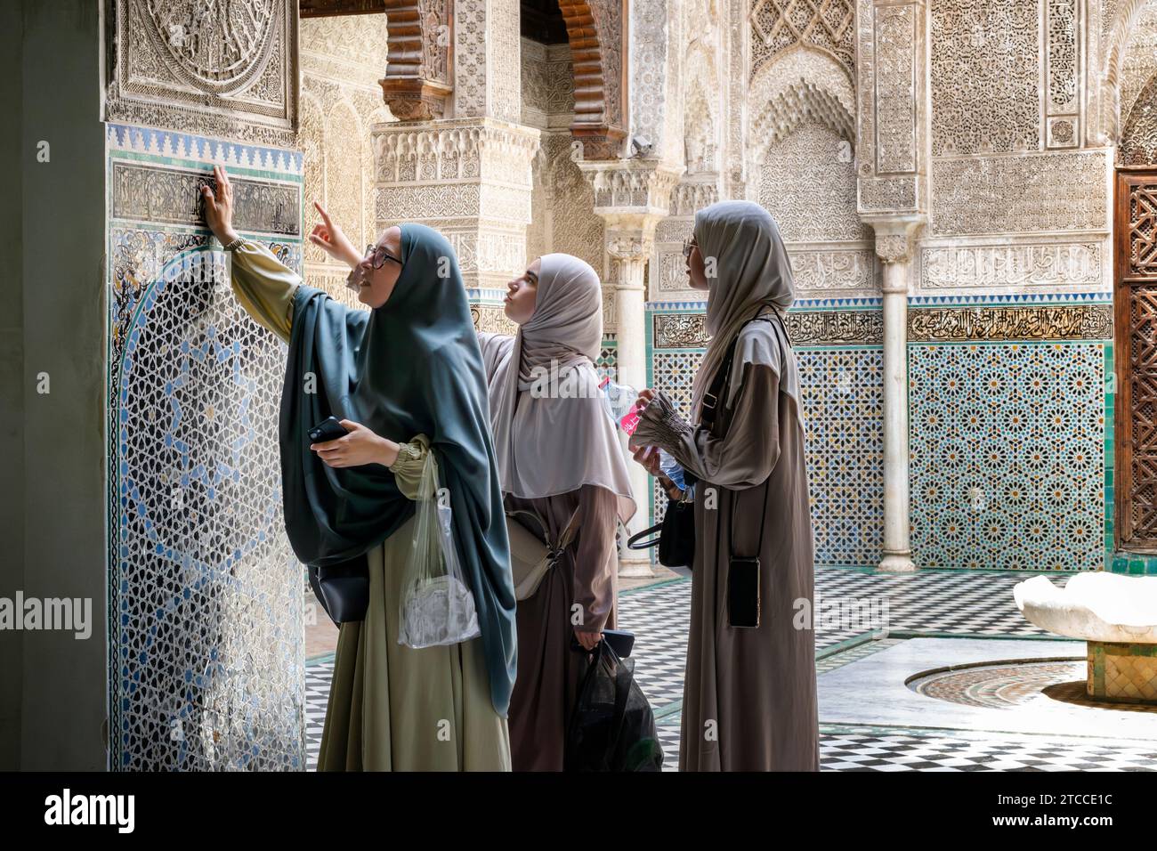 Fes, Marokko: Drei arabische Frauen besuchen die Al-Attarine Madrasa (islamische Religionsschule). Stockfoto