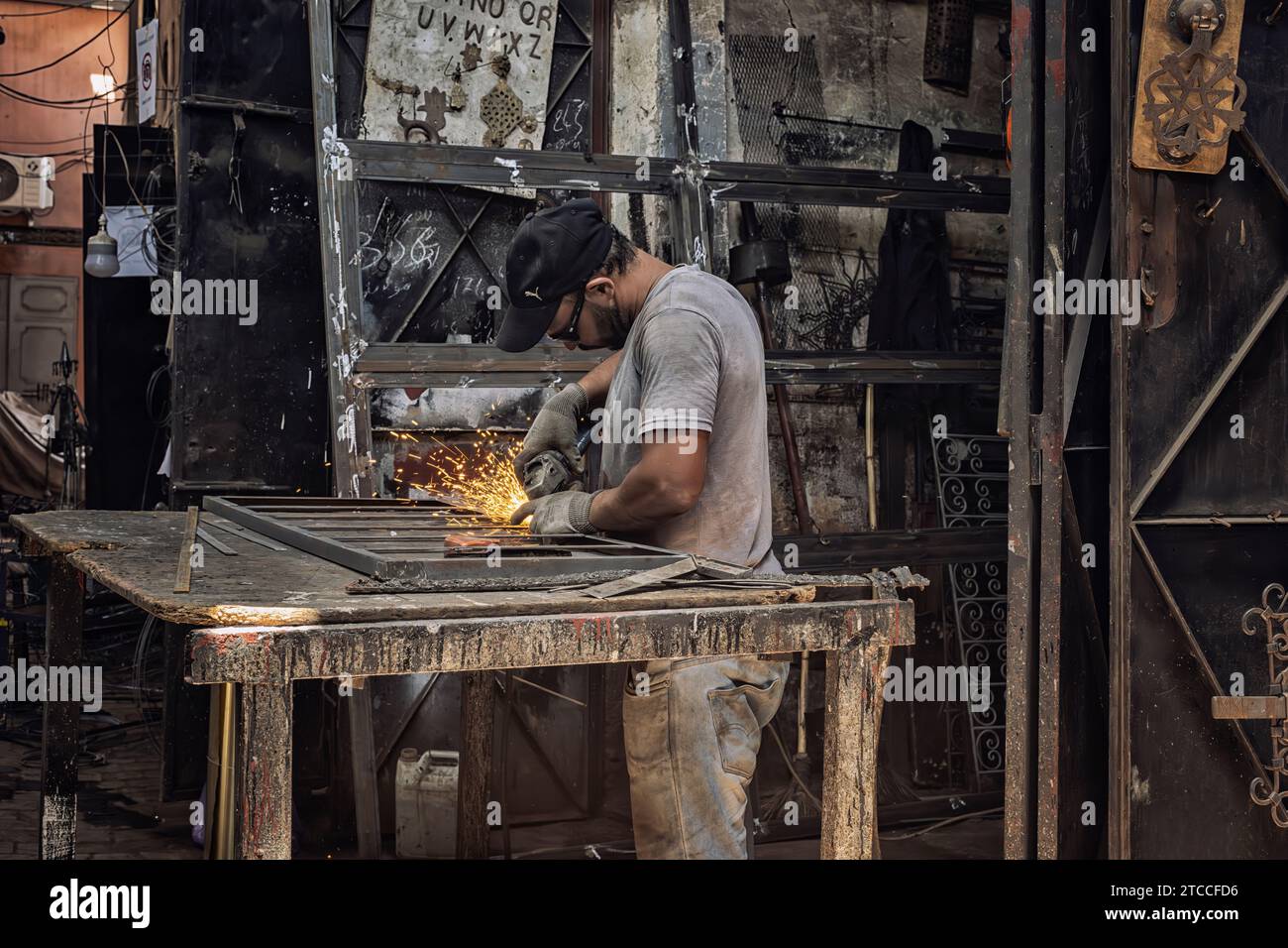 Marrakesch, Marokko: Schmied arbeitet in einer Werkstatt im Souk der Marrakesch Medina. Marokkanischer Handwerker, der beim Schweißen Funken erzeugt. Stockfoto