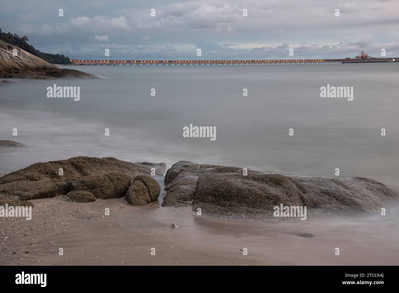 Langsame Aufnahmen der Meereswellen entlang des felsigen Strandes. Stockfoto