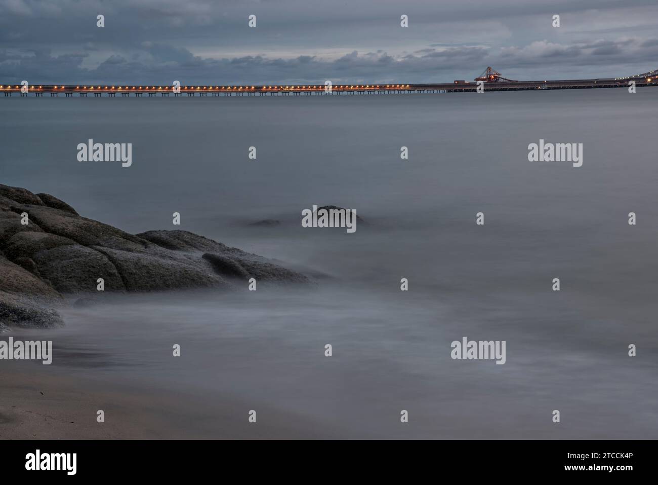 Langsame Aufnahmen der Meereswellen entlang des felsigen Strandes. Stockfoto