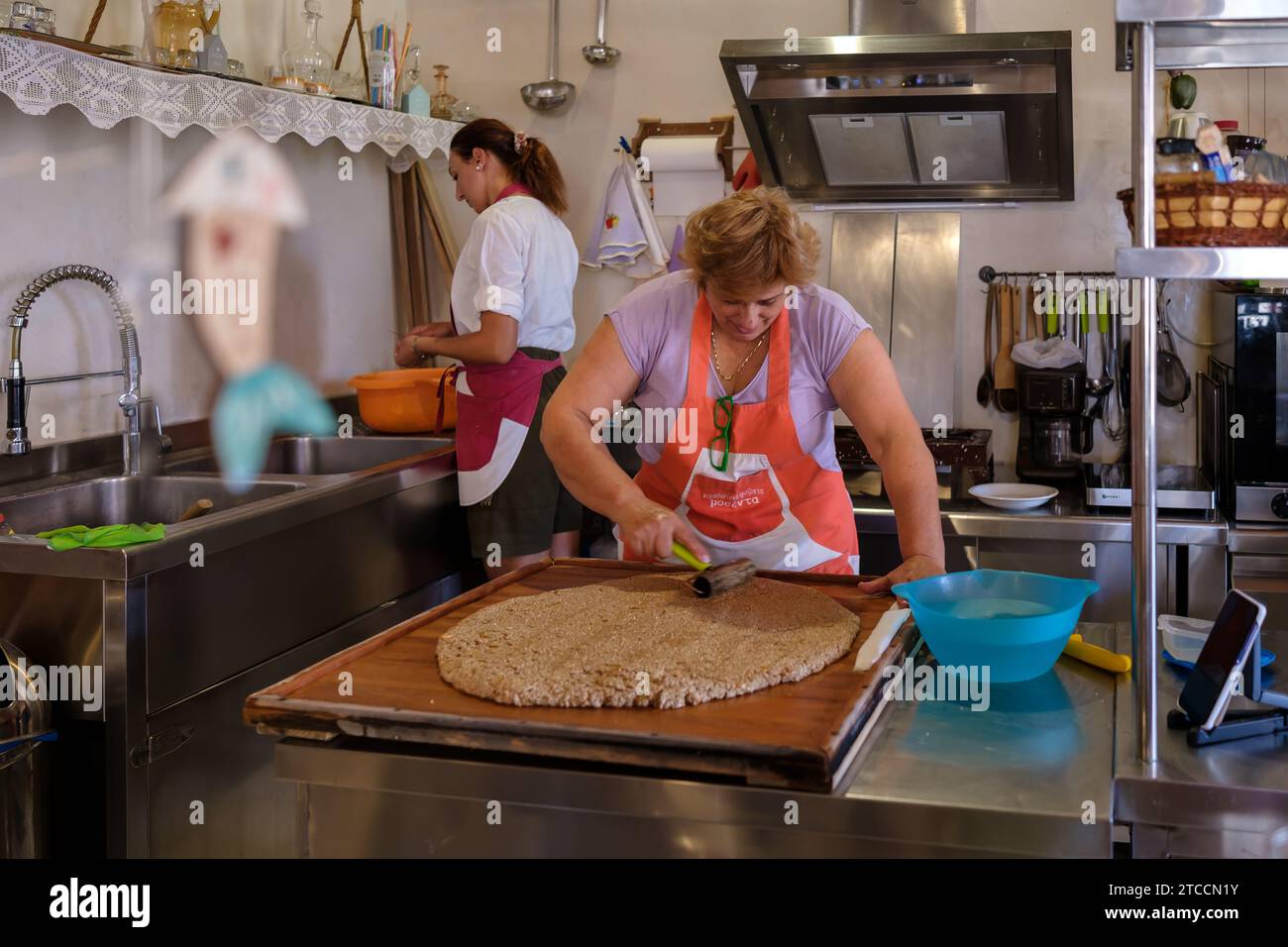 IOS, Griechenland - 13. September 2023 : Ansicht einer Frau, die in iOS Griechenland das traditionelle Pasteli zubereitete, ein Sesambonbon mit Honig Stockfoto