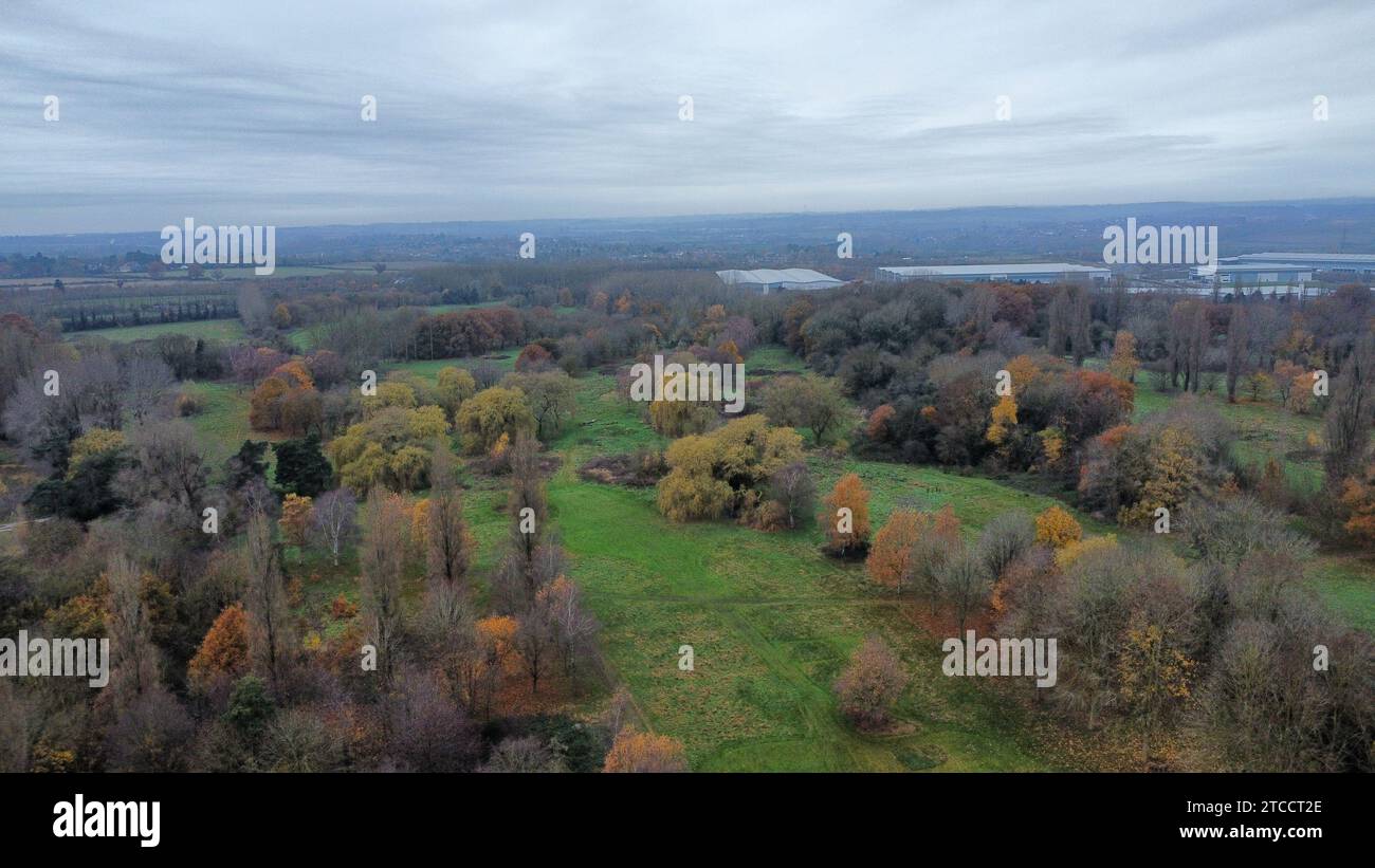 Ein Blick aus der Vogelperspektive auf eine malerische Landschaft mit üppigem Grün, einschließlich grasbewachsenen Feldern, Bäumen und einem Gewässer Stockfoto