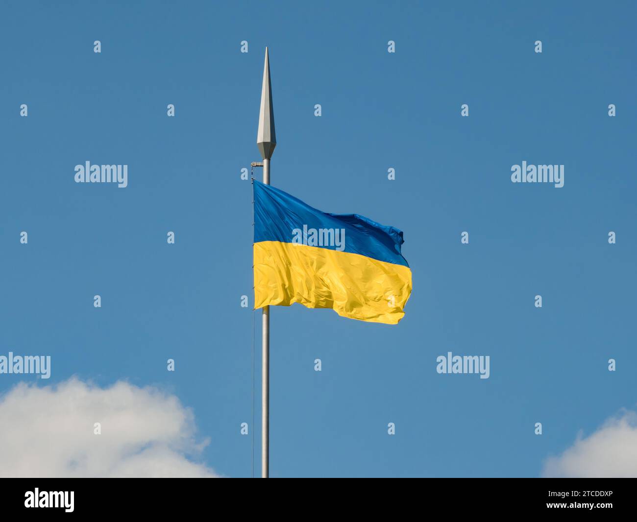 Die Nationalflagge der Ukraine flattert im Wind auf einem hohen Fahnenmast vor dem Hintergrund des Himmels und Wolken aus nächster Nähe Stockfoto