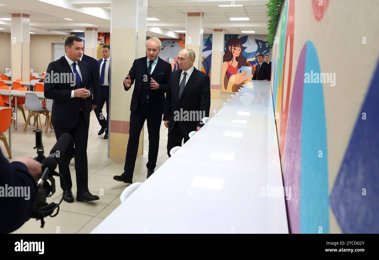 Sewerodwinsk, Russland. Dezember 2023. Der russische Präsident Wladimir Putin, rechts, hört Schuldirektor Ilja Ivankin, Zentrum, und Gouverneur der Region Archangelsk Alexander Sybulski, links, während einer Tour durch die Schule Nr. 7 am 11. Dezember 2023 in Archangelsk, Russland. Quelle: Mikhael Klimentyev/Kreml Pool/Alamy Live News Stockfoto