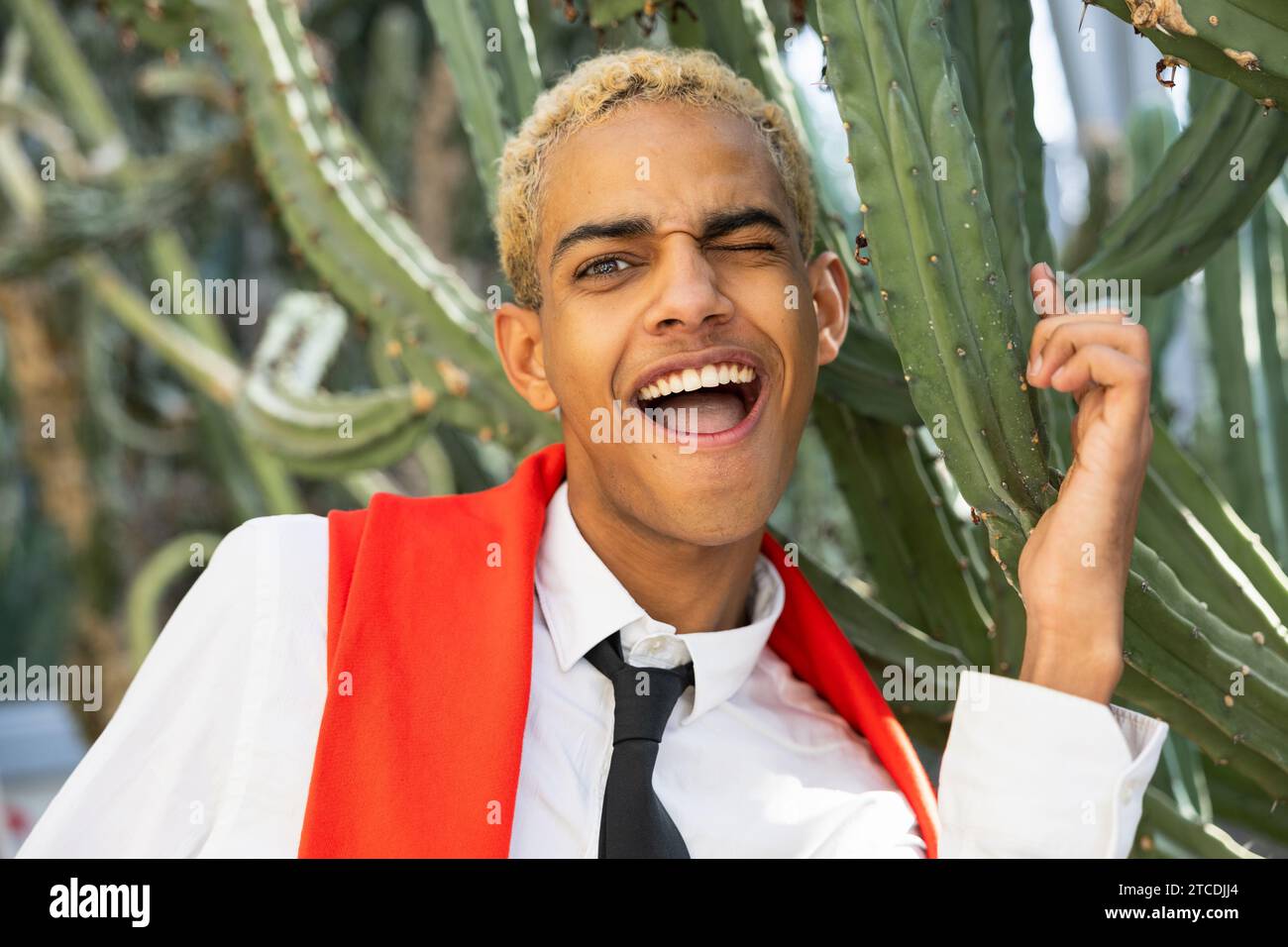 Porträt eines schönen Jungen mit Ausdruck des Schmerzes, der sich mit Kaktuswirbelsäule stechen lässt Stockfoto